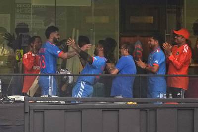 Virat Kohli, second left, is greeted by teammates in the dressing room. AP