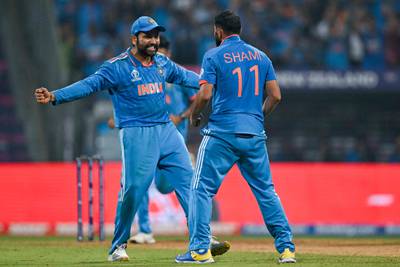 India's captain Rohit Sharma celebrates with teammate Mohammed Shami after the dismissal of New Zealand's Tom Latham. AFP