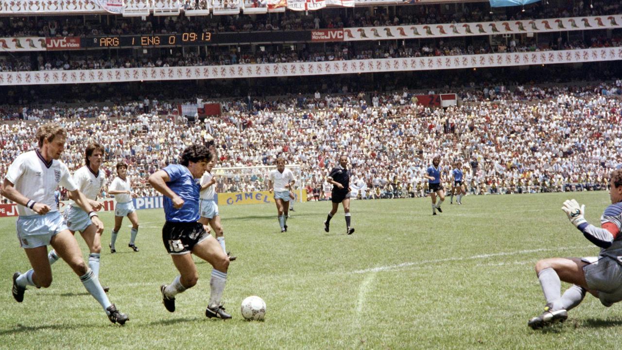 Diego Maradona runs past English defender Terry Butcher on his way to dribbling goalkeeper Peter Shilton and scoring his second goal, or goal of the century.0 (Photo by STAFF / AFP)