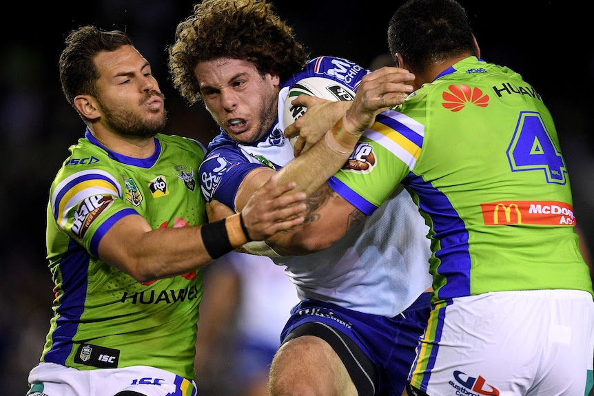 Adam Elliott is tackled by the Canberra Raiders defence.