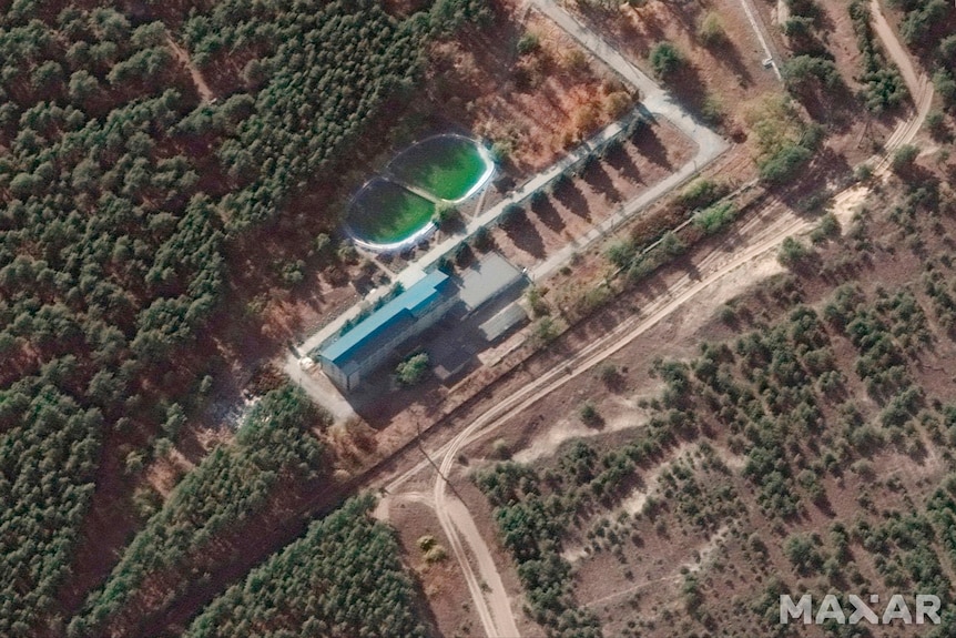 A birds eye view of a building, it is surrounded by trees.